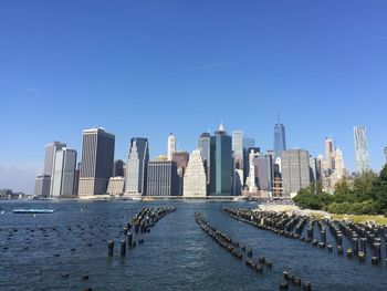 City at waterfront against blue sky