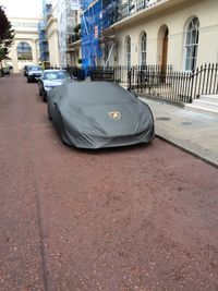 Car on street by buildings in city