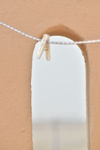 Close-up of clothespins hanging on rope against wall