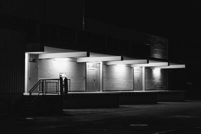 Empty parking lot against building at night