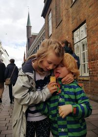 Two children cute hug on the street.