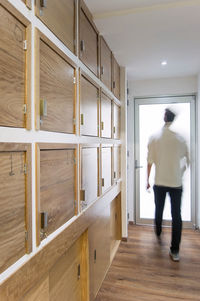 Young man, hispanic boy, walking with sweeping effect, in the lockers of an exercise gym