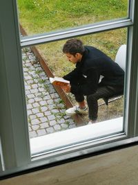 Man looking through window