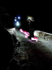 Woman on illuminated street at night