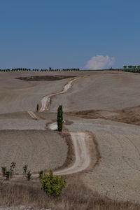 Scenic view of hill with road thorough  the desert against sky