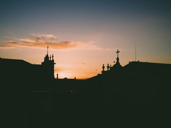 Silhouette buildings against sky during sunset