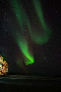 Low angle view of illuminated buildings against sky at night