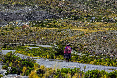 Rear view of woman walking on landscape