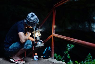 Rear view of a man holding lamp