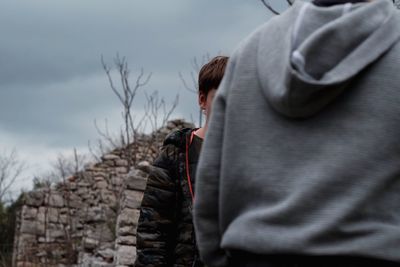 Rear view of woman standing against wall