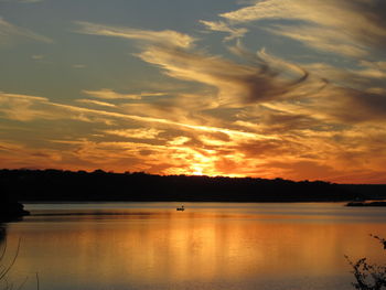 Scenic view of lake against orange sky