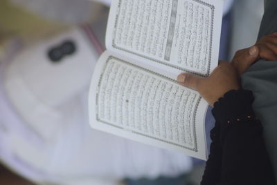 Midsection of woman holding koran