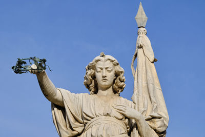 Low angle view of statue against blue sky