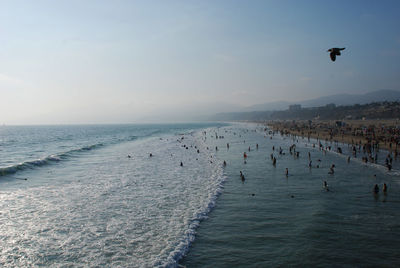 People at beach against sky