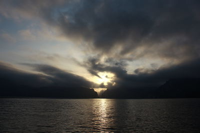 Scenic view of sea against dramatic sky during sunset