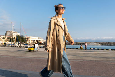 Portrait of young woman standing against sea