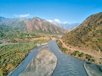 Scenic view of river amidst mountains against sky