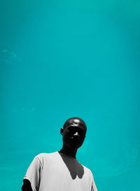 Low angle view of young man against blue sky