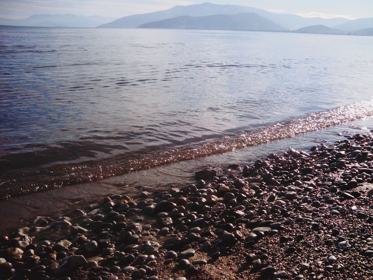 water, sea, scenics, tranquil scene, tranquility, mountain, beauty in nature, beach, nature, shore, sky, idyllic, high angle view, coastline, mountain range, outdoors, non-urban scene, remote, lake, day