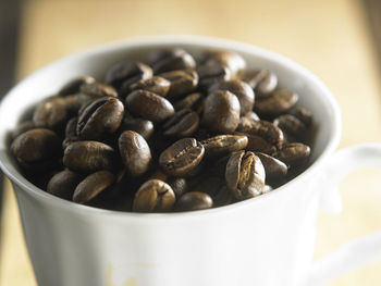 Close-up of roasted coffee beans in cup