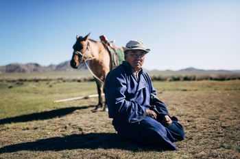 MAN WITH HORSE ON THE FIELD