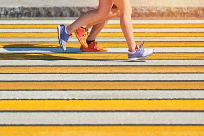 Low section of woman walking on road