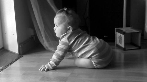 Baby girl sitting on floor at home