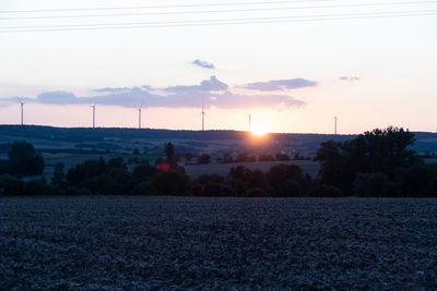 Scenic view of field against sky at sunset