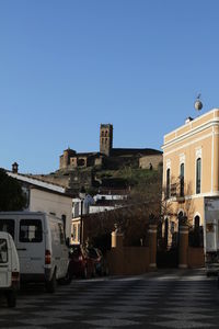 View of buildings against clear blue sky