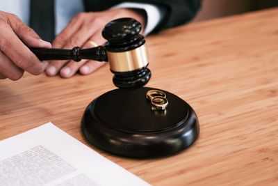 Midsection of lawyer holding gavel at table in office