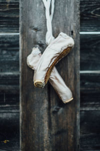 Ballet shoes hanging from wooden wall