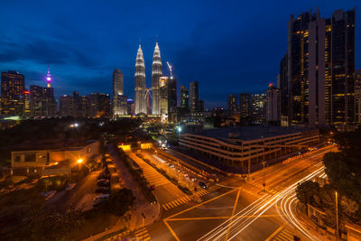 Illuminated cityscape against sky at night