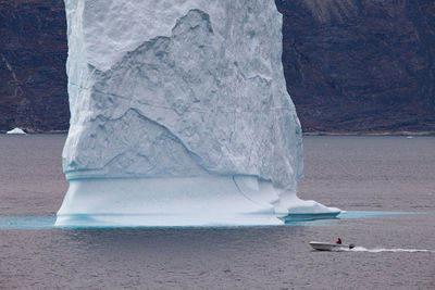 Scenic view of iceberg and boat 