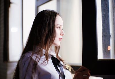 Close-up of young woman looking through window