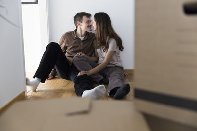 Affectionate multiracial couple kissing each other while sitting at home