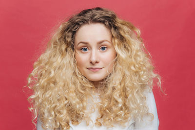 Portrait of young woman against yellow background