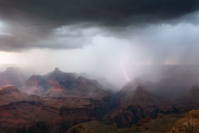 A dramatic thunderstorm with lightning sweeps across the grand canyon.
