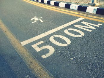 High angle view of arrow symbol on road in city