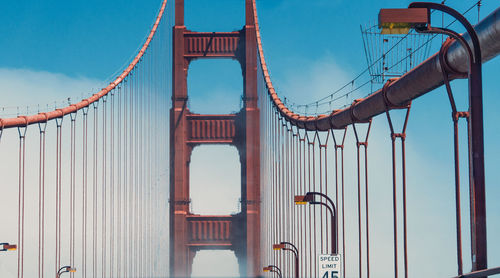 Low angle view of suspension bridge against sky