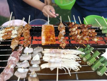 Close-up of person preparing food on barbecue grill