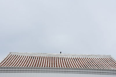 Low angle view of building roof against clear sky