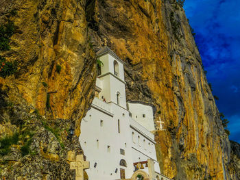 Low angle view of old building by mountains against sky