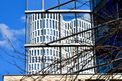 Low angle view of modern building against blue sky