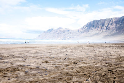 Scenic view of beach and mountains against sky