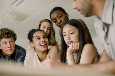 Low angle view of teacher with teenagers in classroom