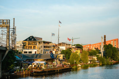 River amidst buildings in city against sky