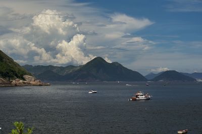 Scenic view of sea and mountains against sky