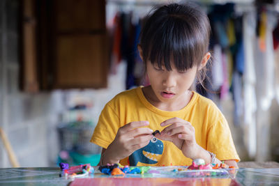 Cute girl playing with clay at home