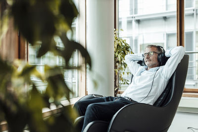 Reflection of man sitting on seat in window