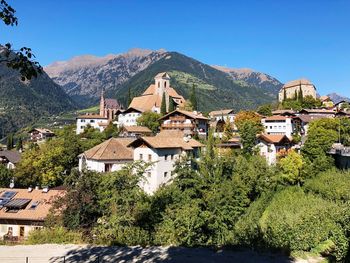 Houses by trees and mountains against sky